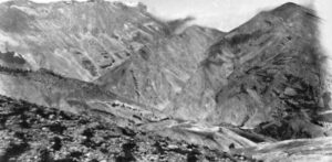Photographie panoramique en noir et blanc de 1897 : paysage de haute montagne aride et dénudé vu depuis le col de Chabanottes, avec des versants érodés et un chemin serpentant dans le vallon.