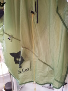 Tente ultralight verte de marque Nigth-Cat suspendue et étendue à l'intérieur d'un logement pour séchage, avec ses haubans jaunes encore attachés, au retour d'une randonnée itinérante en Suisse Normande.