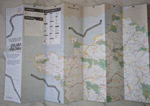 Carte papier grand format Recto Verso partiellement dépliée, montrant la partie nord-ouest de la France avec ses points d'intérêt outdoor codés par couleur, sa légende et son index des régions et départements