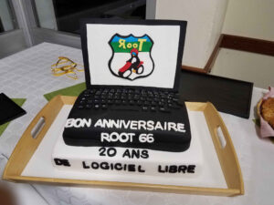 Photo d'un gâteau d'anniversaire décoré avec le logo Root 66 et l'inscription "20 ans de logiciel libre". En arrière-plan, on aperçoit des des décorations festives (photo/image @Sima78, licensed under CC BY-NC-SA).