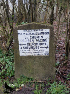 Borne en pierre ancienne portant une plaque émaillée indiquant « Le Chemin de Jean Racine, de Port-Royal à Chevreuse », avec une citation du poète datée de 1656, dans un sous-bois en hiver. Don du Touring Club. Photo ©Sima78.
