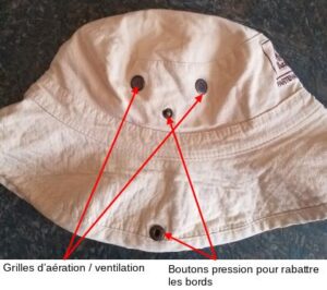 Vue de face du bob de randonnée beige Dakar, avec annotations en rouge identifiant les grilles d'aération/ventilation et les boutons pression permettant de rabattre les bords.