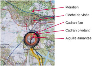 Photo annotée d'une boussole à semelle McKinley posée sur une carte IGN au 1/25 000e de la région de Saint-Cyr-l'École et Versailles, avec cinq flèches rouges identifiant le méridien de référence, la flèche de visée, le cadran fixe, le cadran pivotant et l'aiguille aimantée, la semelle alignée sur un méridien de la carte.