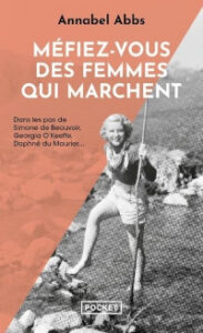 Couverture du livre « Méfiez-vous des femmes qui marchent » d'Annabel Abbs, édition Pocket. Une femme en short et chemise, un bâton à la main, pose sur un rocher en montagne. Le sous-titre mentionne Simone de Beauvoir, Georgia O'Keeffe et Daphné du Maurier.