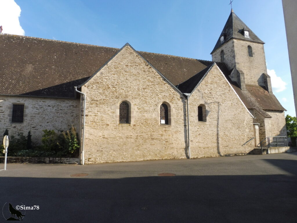 Photographie de l'église Saint-Martin de Préveranges, édifice en pierre avec clocher à flèche d'ardoise et horloge, sous un ciel bleu dégagé.
